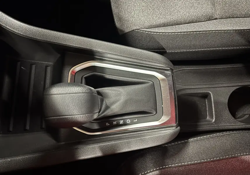 Gros plan sur le levier de vitesses automatique noir de la Renault Clio TCe 90ch Evolution, entouré de garnitures grises.