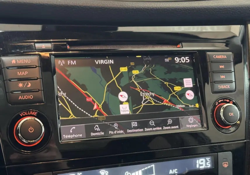 Vue rapprochée de l’écran tactile de navigation et des commandes noires du tableau de bord du Nissan Qashqai gris foncé.