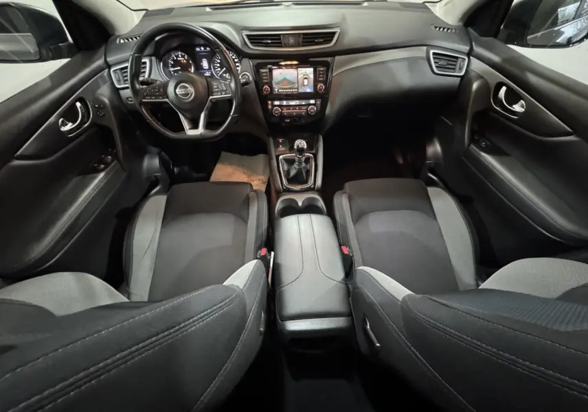 Intérieur noir et gris du Nissan Qashqai 2019, vue avant centrée sur le tableau de bord et volant multifonctions.