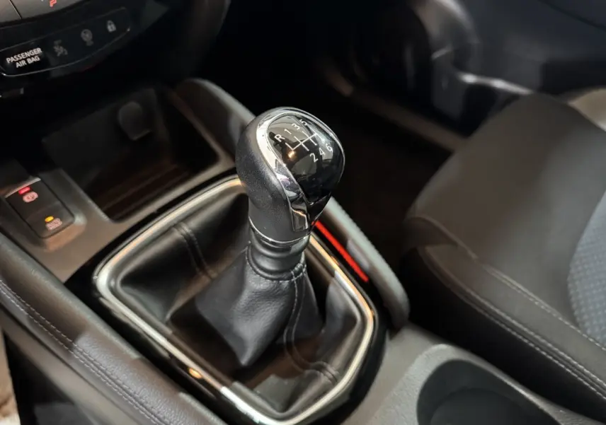 Gros plan sur le levier de vitesses manuel en cuir noir du Nissan Qashqai 2019, intérieur gris foncé.