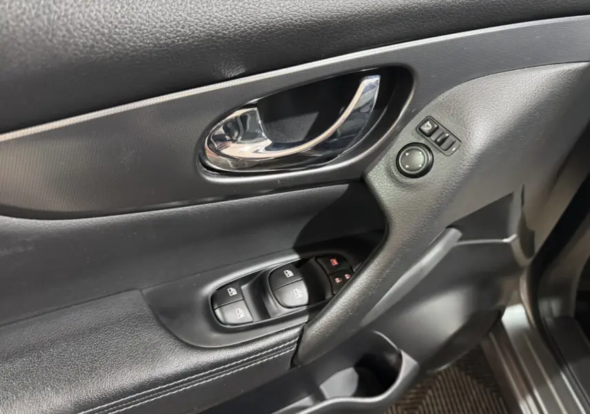 Gros plan sur la porte avant gauche du Nissan Qashqai gris foncé, avec commandes vitres et rétroviseurs.