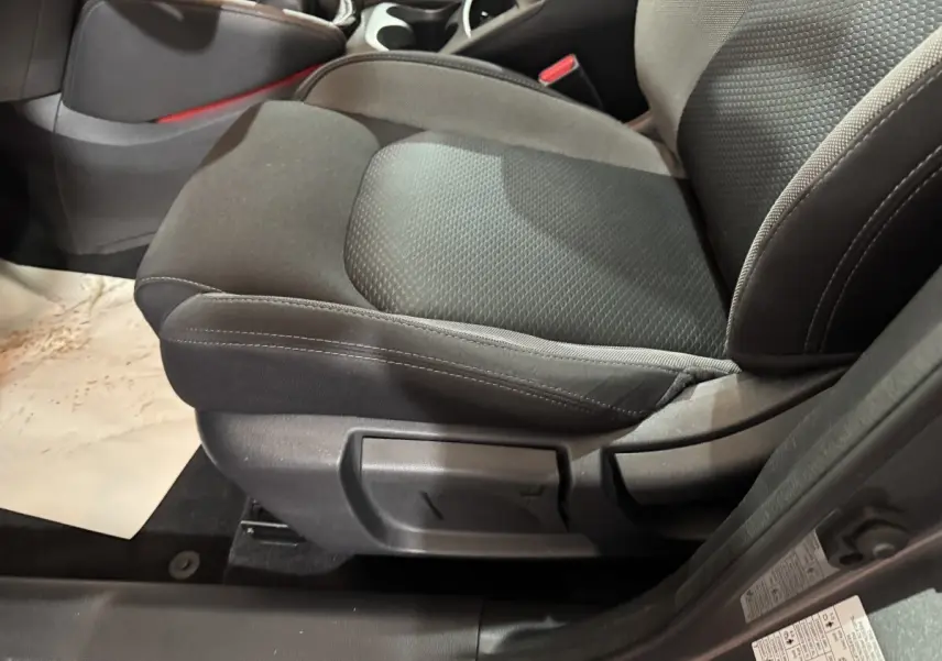 Gros plan sur le siège avant droit tissu gris foncé du Nissan Qashqai 2019, avec réglage manuel visible.