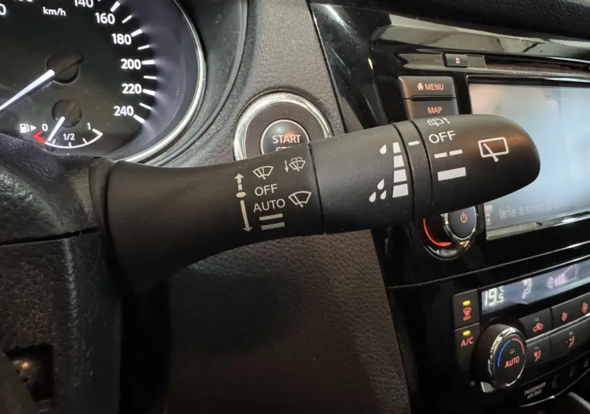 Gros plan sur la commande d’essuie-glace noire du Nissan Qashqai gris foncé, avec tableau de bord et bouton start visibles.