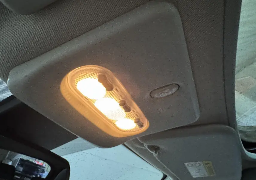 Plafonnier intérieur allumé vu de dessous dans un Nissan Qashqai gris foncé, version 2019 essence.