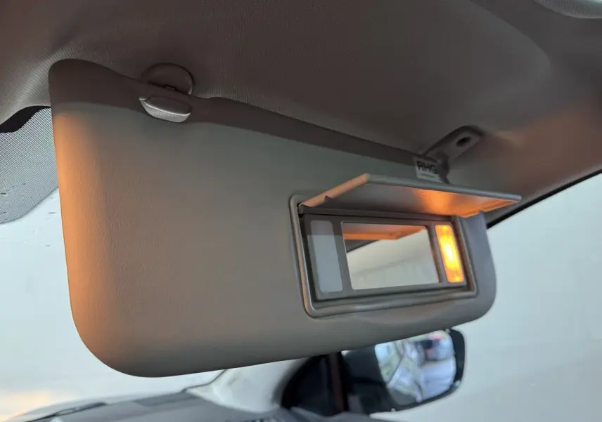 Détail du pare-soleil côté conducteur avec miroir éclairé dans un Nissan Qashqai gris foncé 2019.