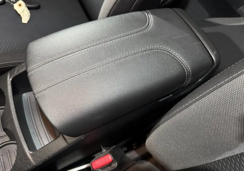 Gros plan sur l'accoudoir central en cuir noir du Nissan Qashqai 1.3 DIG-T 140 N-Connecta 2019, intérieur sombre.