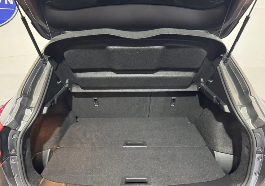 Coffre ouvert du Nissan Qashqai gris foncé, vue arrière montrant l'espace de chargement plat et spacieux.