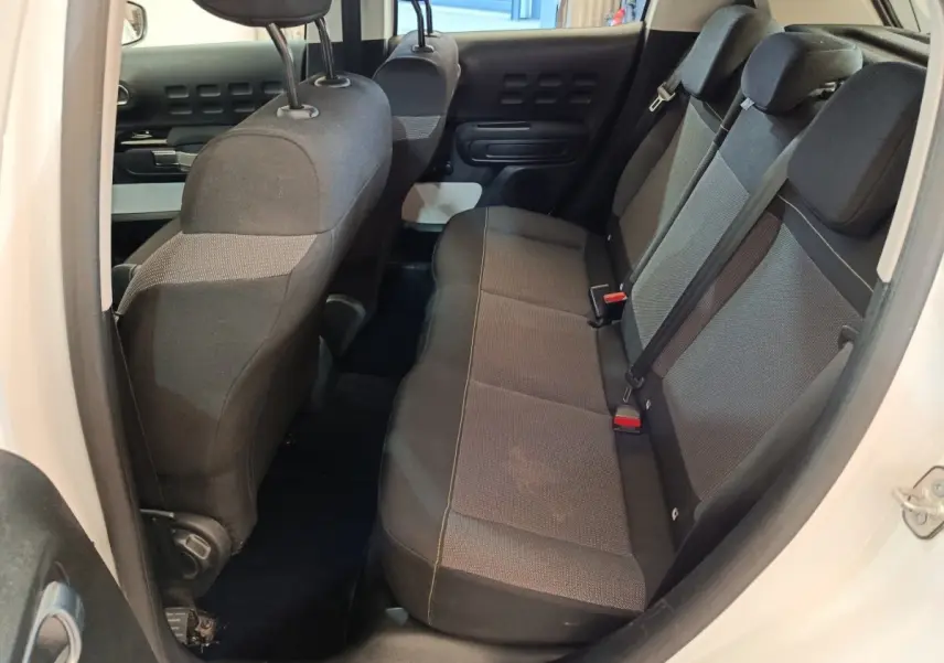 Vue intérieure côté droit montrant la banquette arrière noire et grise du Citroën C3 blanc de 2021.