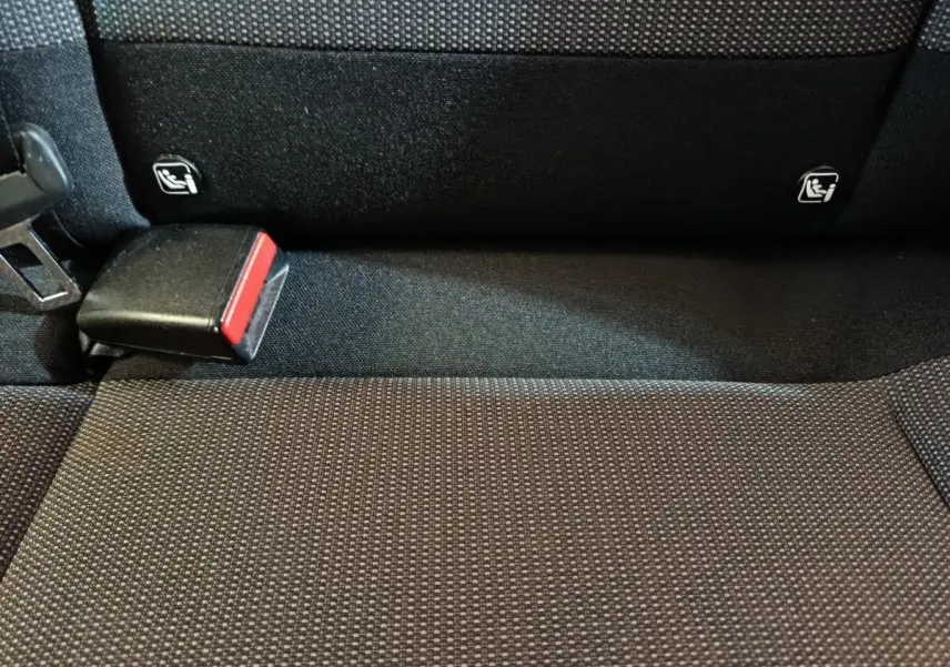 Gros plan sur la banquette arrière noire de la Citroën C3 avec attaches Isofix et boucle de ceinture rouge visible.