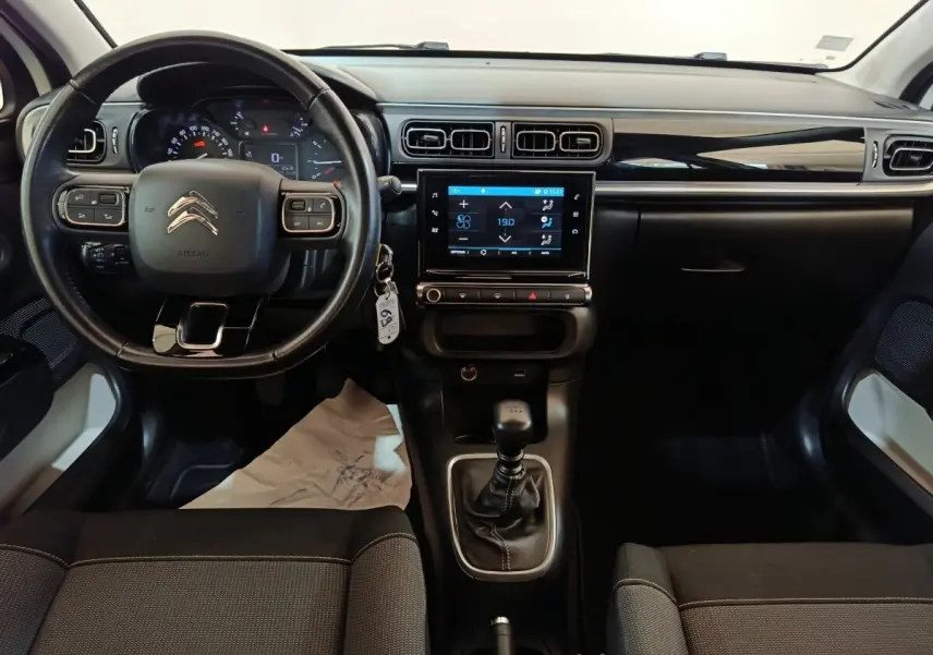 Vue intérieure avant du tableau de bord et volant cuir noir d'une Citroën C3 2021 avec écran tactile central.