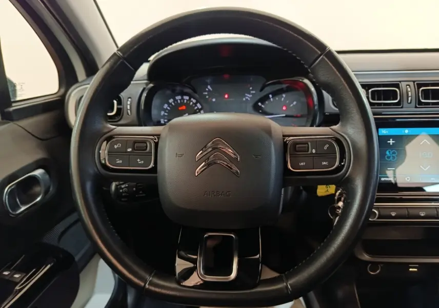 Vue centrée sur le volant cuir noir de la Citroën C3 2021 avec commandes intégrées et tableau de bord numérique.