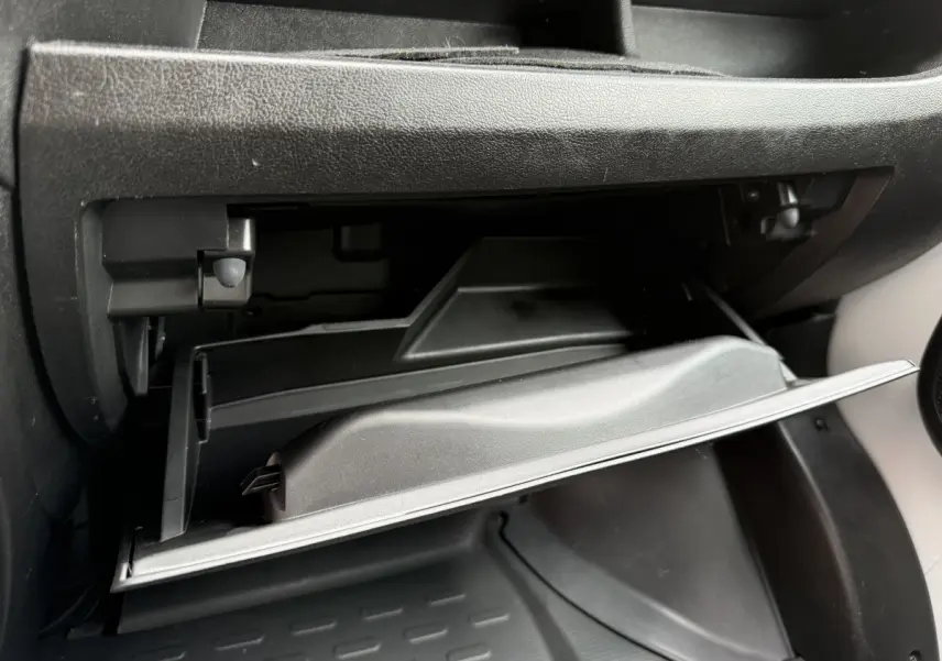 Vue rapprochée de la boîte à gants ouverte côté passager du Peugeot Boxer Fourgon blanc, intérieur noir.