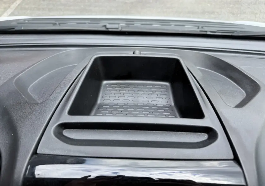 Vue rapprochée du rangement central noir sur le tableau de bord du Peugeot Boxer Fourgon blanc 2023.