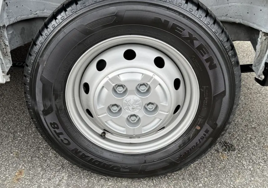 Gros plan sur la roue avant droite du Peugeot Boxer Fourgon blanc, avec jante acier et pneu Nexen visible.