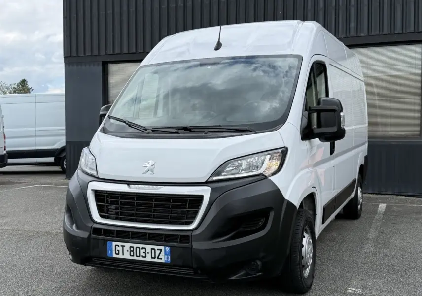 Vue 3/4 avant droit d’un Peugeot Boxer Fourgon blanc avec calandre noire et pare-chocs noir mat.