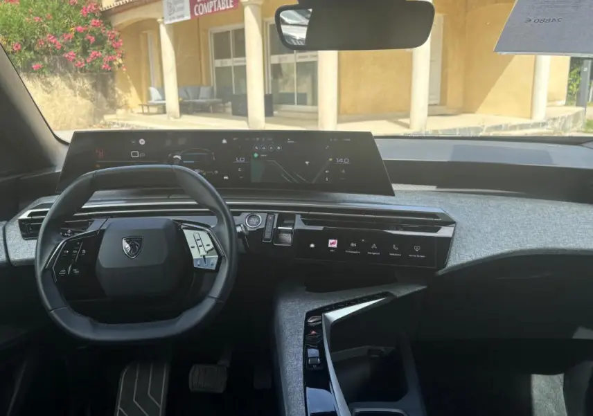 Vue intérieure du tableau de bord du Peugeot 3008 Hybrid 136 e-DCS6 Allure 2025 noir, avec volant compact et double écran numérique.