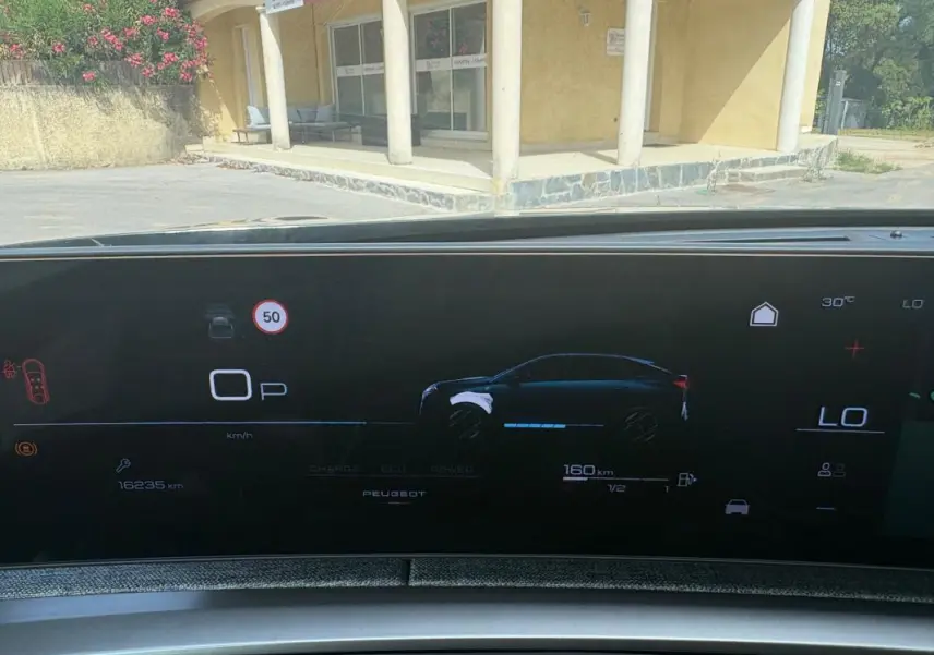 Affichage numérique du cockpit du Peugeot 3008 Hybrid 136 e-DCS6 Allure montrant l'autonomie et la vitesse, vue intérieure frontale.
