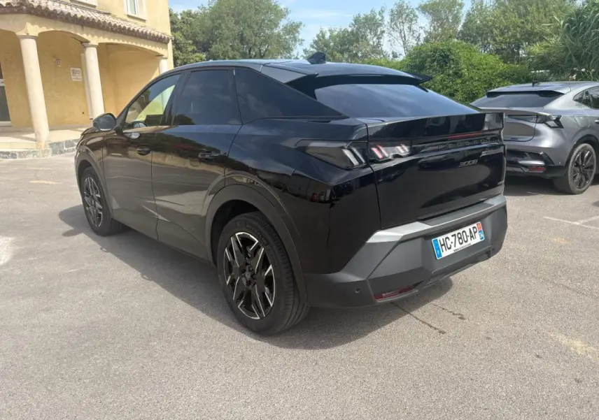 Peugeot 3008 Hybrid noir en 3/4 arrière droit, jantes alliage 19 pouces et feux arrière distinctifs allumés.