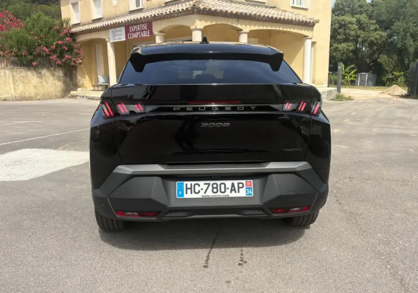 Vue arrière d’un Peugeot 3008 Hybrid noir 2025 avec feux distinctifs à triple griffes et plaque d’immatriculation française.