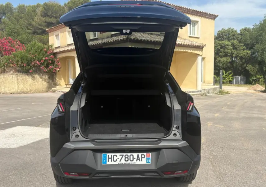 Vue arrière d'un Peugeot 3008 Hybrid noir 2025 avec coffre ouvert, feux arrière LED et plaque d'immatriculation française visible.