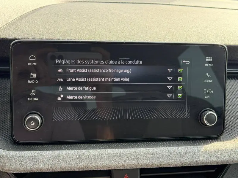 Écran tactile central du tableau de bord de la Skoda Scala 2025 affichant les réglages d'aide à la conduite.