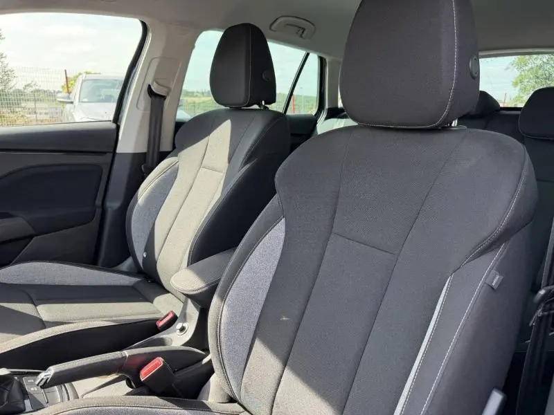 Gros plan sur les sièges avant en tissu noir et gris de la Skoda Scala 2025, intérieur lumineux et épuré.