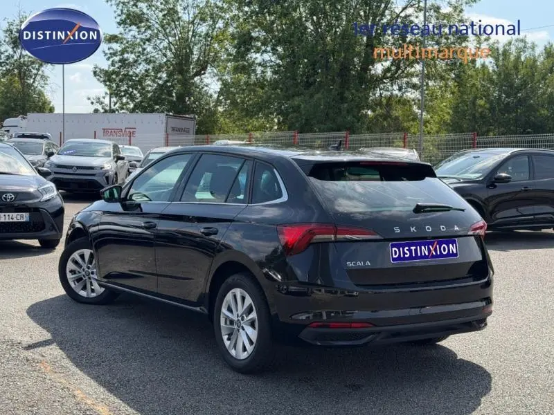 Vue 3/4 arrière droite d'une Skoda Scala noire Magic nacré avec jantes alu et feux arrière LED visibles.