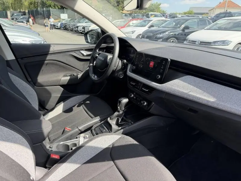 Intérieur avant droit de la Skoda Scala 2025, tableau de bord noir et gris avec écran tactile et volant multifonction.