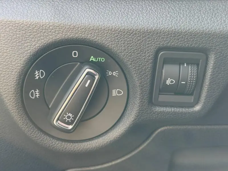 Gros plan sur la commande d’éclairage intérieur du Skoda Scala noir Magic nacré, avec réglage automatique et manuel des phares.