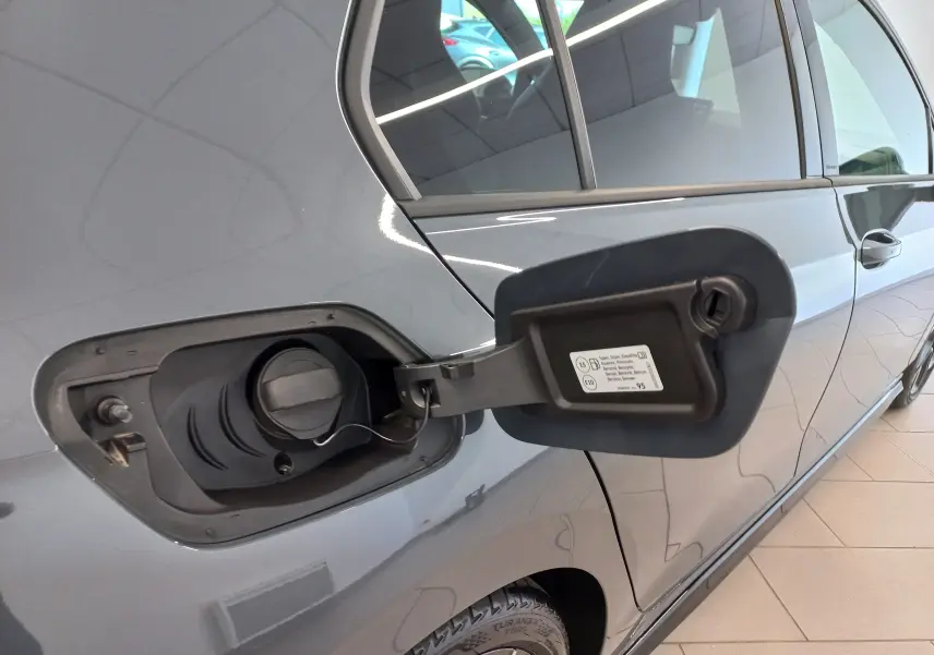 Vue latérale gauche rapprochée d’une Volkswagen Golf 1.5 eTSI Gris Dauphin avec trappe à carburant ouverte montrant le bouchon essence.