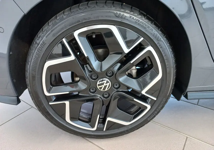 Gros plan sur la jante noire et argentée du côté gauche d'une Volkswagen Golf 1.5 eTSI 150 DSG7 R-Line Gris Dauphin.