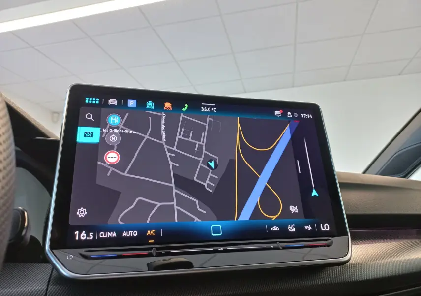 Écran tactile du système d'infodivertissement de la Volkswagen Golf 1.5 eTSI R-Line 2025 affichant la navigation et la climatisation.