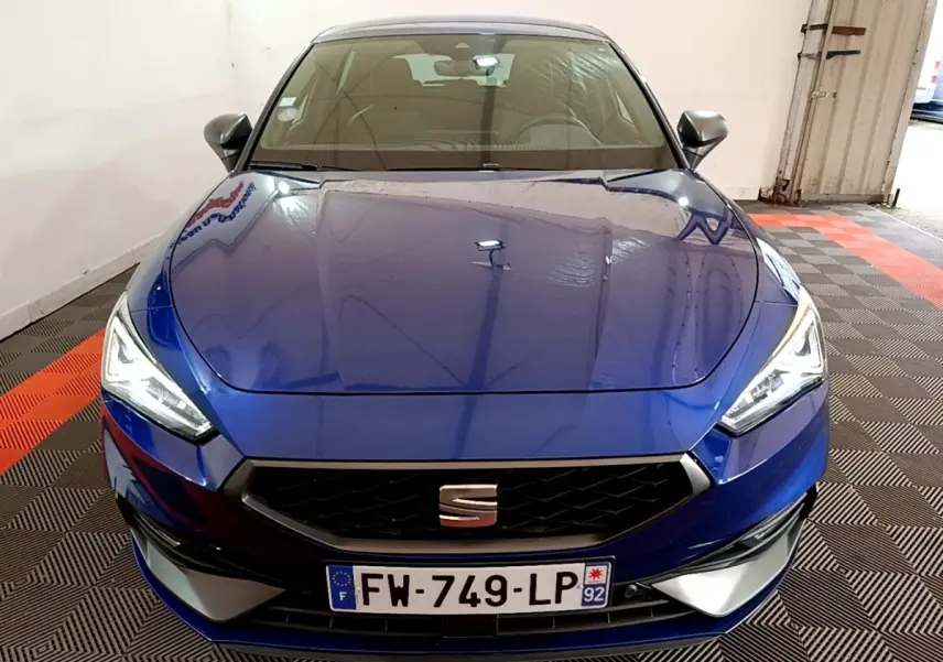 Vue avant d'une SEAT Leon 1.5 eTSI 150 DSG FR bleu, avec calandre noire et phares LED allumés.