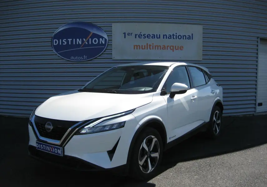 Nissan Qashqai blanc nacré en 3/4 avant droit, avec calandre noire et jantes bicolores distinctives.