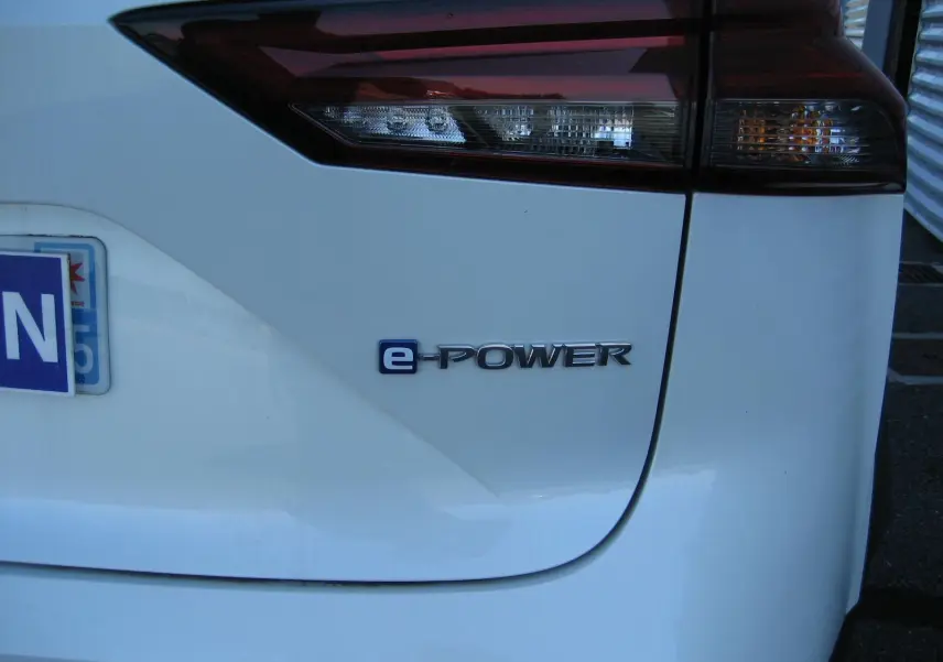 Gros plan sur le feu arrière droit et le logo e-POWER d’un Nissan Qashqai blanc nacré de 2024.