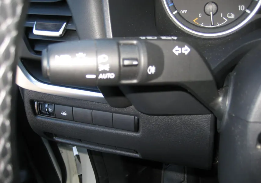 Gros plan sur la commande de clignotants et les boutons de réglage d'assistance au conducteur du Nissan Qashqai blanc nacré 2024.