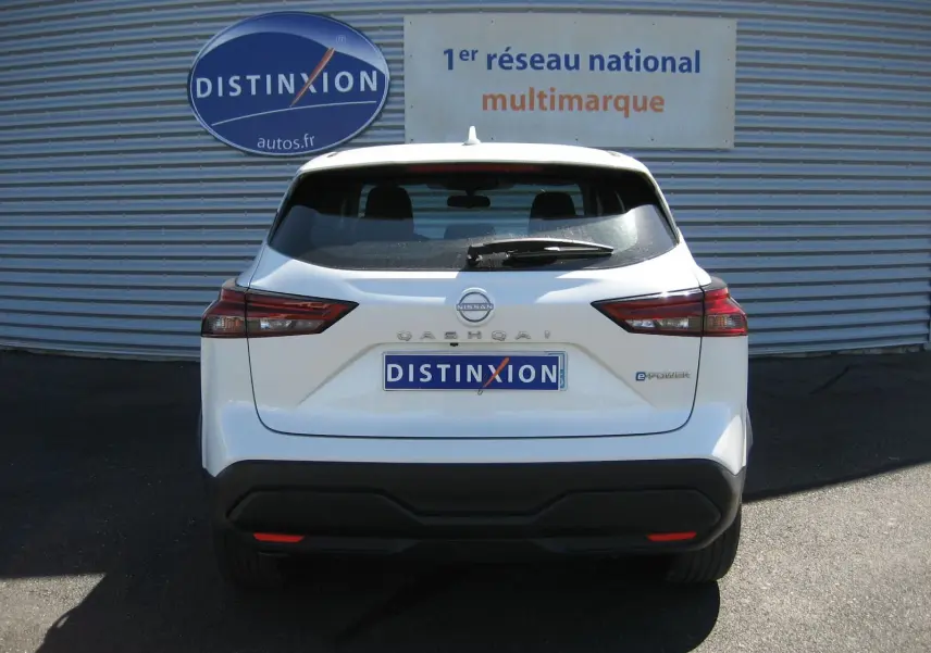 Vue arrière d'un Nissan Qashqai blanc nacré 2024 avec logo e-POWER et plaque Distinxion visible.