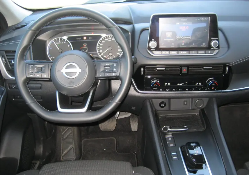Vue intérieure avant du tableau de bord et volant d'une Nissan Qashqai 2024, avec écran tactile et commandes modernes.
