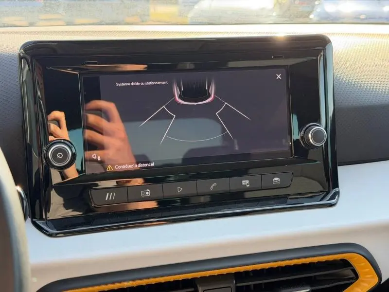 Écran tactile central du tableau de bord du SEAT Arona 2025 montrant l'aide au stationnement en mode nuit.