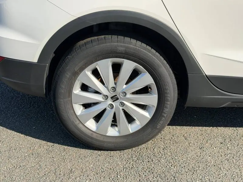 Gros plan sur la roue arrière droite d’un SEAT Arona blanc Candy avec jante alu et entourage noir.