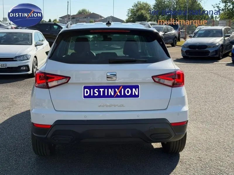 Vue arrière d'un SEAT Arona blanc Candy avec toit noir Minuit, feux LED et logo distinctif au centre.