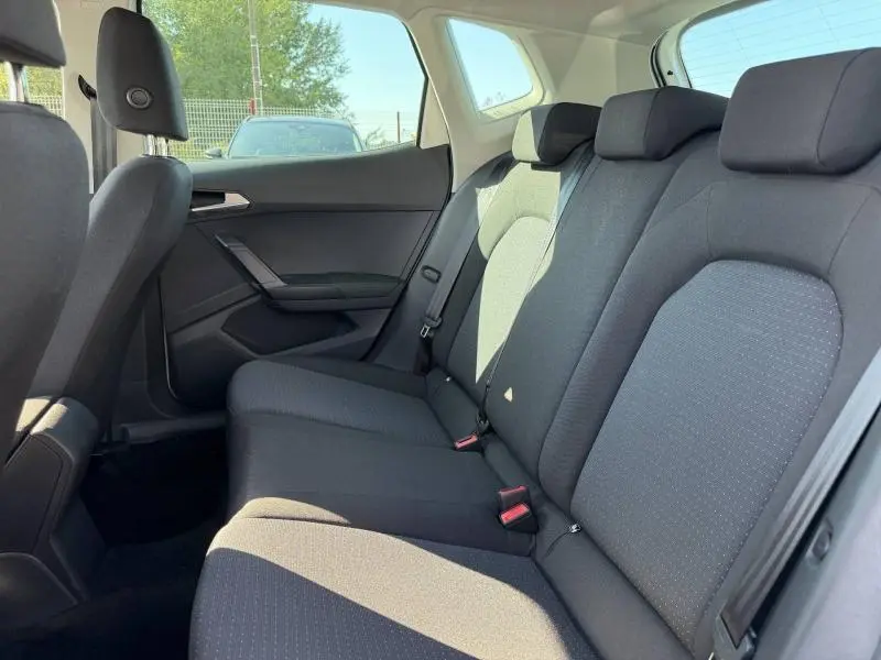 Vue intérieure côté droit de la banquette arrière en tissu gris de la SEAT Arona 2025, avec appuie-têtes et ceintures visibles.