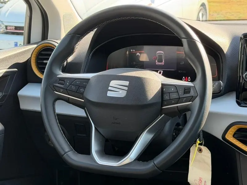 Vue rapprochée du volant cuir multifonction noir du SEAT Arona 2025 avec tableau de bord numérique en arrière-plan.