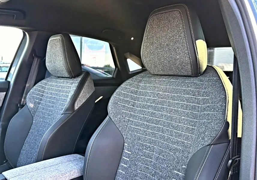 Gros plan sur les sièges avant en tissu gris et cuir noir du Peugeot 3008 1.2 hybrid 145 allure e-dcs6 bleu 2025.