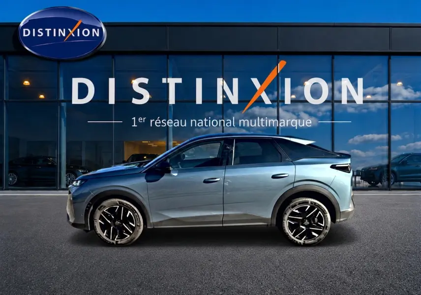 Vue de profil côté gauche du Peugeot 3008 hybride 2025 bleu avec jantes alliage noires devant une vitrine Distinxion.