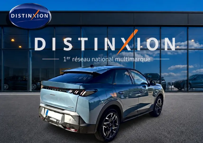 Peugeot 3008 bleu 3/4 arrière droit, avec jantes alu et feux arrière à LED, devant un showroom Distinxion.