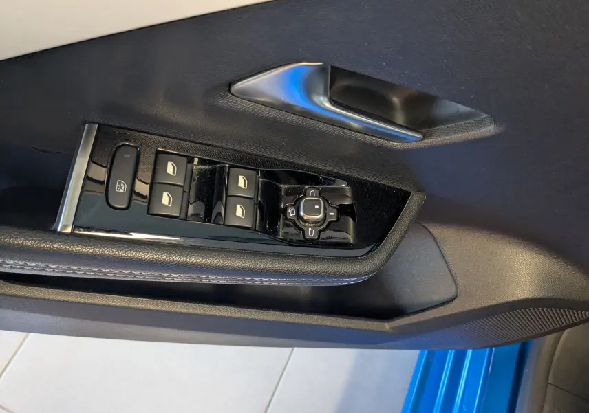 Vue rapprochée des commandes des vitres et du rétroviseur côté conducteur d'une Opel Astra bleu 2022.