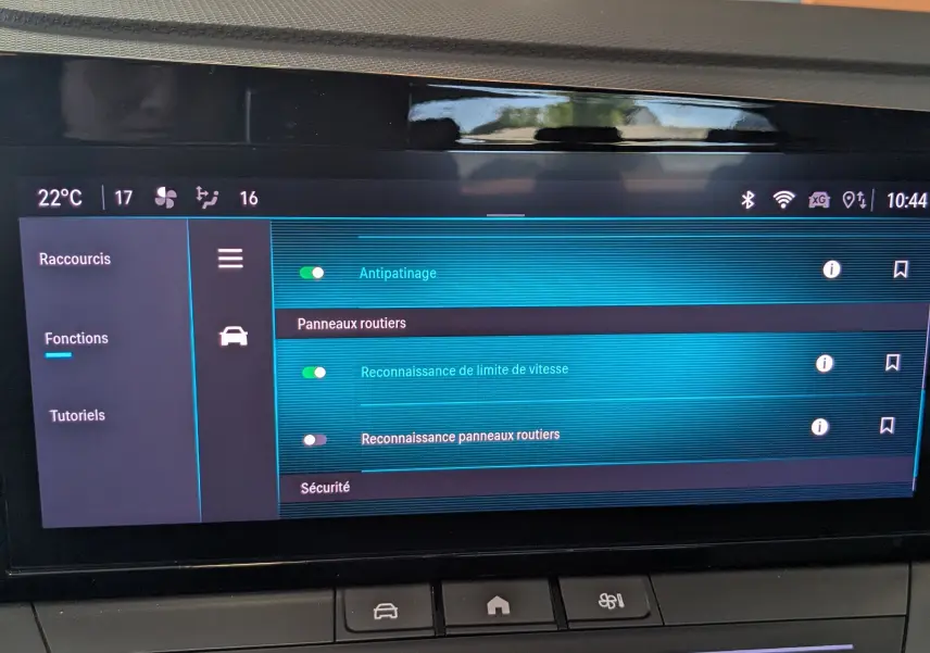 Écran tactile central de l’Opel Astra 2022 bleu, affichant les réglages d’assistance à la conduite et climatisation.