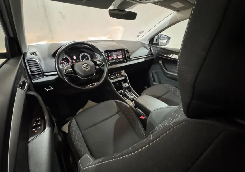 Intérieur noir du Skoda Karoq 2021 vu côté conducteur, avec tableau de bord digital et écran tactile central.