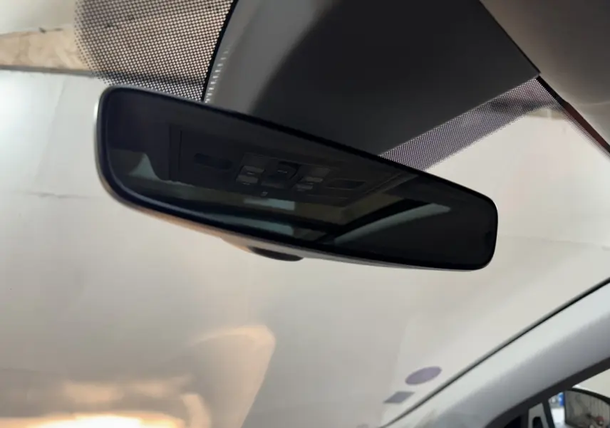 Rétroviseur intérieur noir avec commandes intégrées, vue depuis l’habitacle du Skoda Karoq blanc 2021.